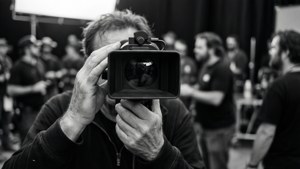 Les mains de Sam Raimi avec un viseur en noir et blanc