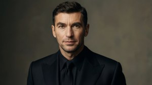 Zinedine Zidane i en formel sort jakkesæt, studieportræt med blød nøglebelysning.