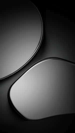 Abstract metallic curves in black and gray with soft shadows and reflections.