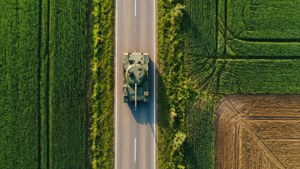 Luftfoto set oppefra af en BMP-1 på en vej omgivet af grønne marker.