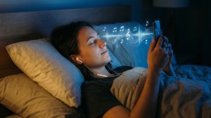 A cozy bedroom scene with a person listening to music via earbuds, surrounded by glowing symbols.