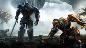 Två gigantiska robotar Optimus Prime och Bumblebee i en krigszon med explosioner. — Transformers Humla bilder Bakgrundsbilder