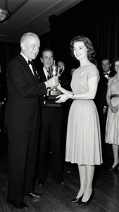 Maureen Connolly vid en formell troféceremoni, tar emot pris från en tjänsteman.
