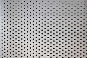 Perforiertes Metallblech mit sich wiederholenden kreisförmigen Löchern für den Hintergrund. — Abstract Dot Wallpaper