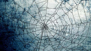 A cracked spiderweb pattern on a weathered blue surface. — Cute Kawaii Aesthetic Background