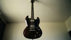 Gibson SG ondersteboven hangend aan het plafond, ongebruikelijk perspectief, abstract
