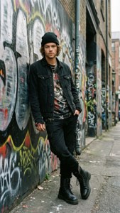 Harry Styles omarmt een edgy stedelijke look in een graffiti-steeg.