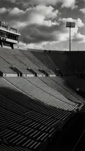 Photo dramatique en noir et blanc du Varsity Stadium vide avec des ombres et une géométrie frappantes