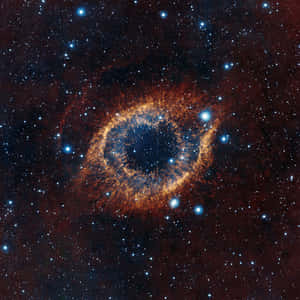 Ögonformad nebulosa med glödande orange ring och blått centrum omgiven av stjärnor. — Utrymme Pc bakgrund Bakgrundsbilder