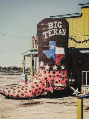 Botte de cowboy géante avec décoration du drapeau du Texas devant un restaurant au coucher du soleil. — Far West Fonds d'écran