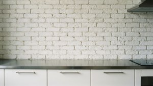 Moderne køkken med en hvid murstensbagplade og rustfrit stål bordplade