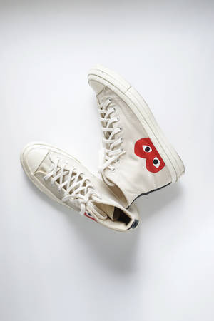 Baskets montantes off-white avec logo œil rouge sur fond blanc.