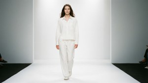 Modelo de branco em um cenário minimalista de passarela branca.