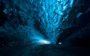 Una cueva de hielo azul con paredes brillantes y una salida brillante adelante. — Windows 11 4K Fondos de pantalla