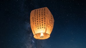 En enkelt indgraveret lanterne, der driver op i en stjerneklar himmel, symbolsk for et ønske.